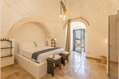 um quarto com uma cama e uma porta para um pátio em Villa Trulli del Gelso em Carovigno