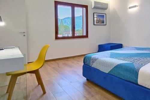 a bedroom with a bed and a desk and a window at Villa Paradiso in Scopello