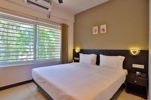 een slaapkamer met een groot bed en 2 ramen bij IVY RESIDENCY in Trivandrum
