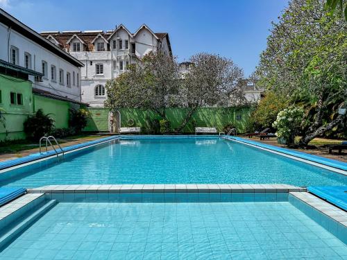 a large swimming pool in a yard with a building at Queen's Hotel in Kandy