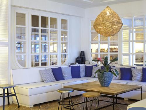 a living room with a white couch and a table at Hotel Els Pins in Platja  d'Aro