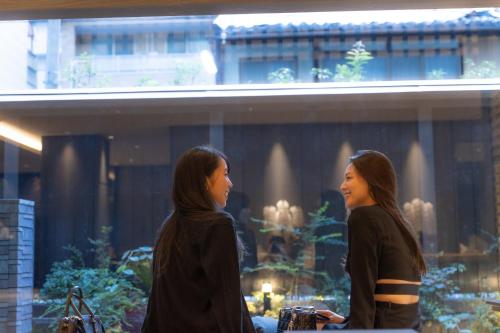 two women walking in front of a building at THE BLOSSOM KYOTO in Kyoto