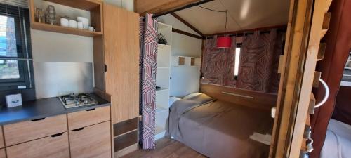 a small room with a couch in a tiny house at CAMPING ONLYCAMP VAUBAN in Neuf-Brisach