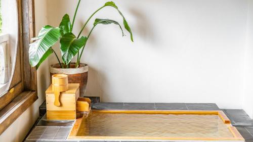 a table with a potted plant next to a window at Shorenkan Yoshinoya in Kyotango