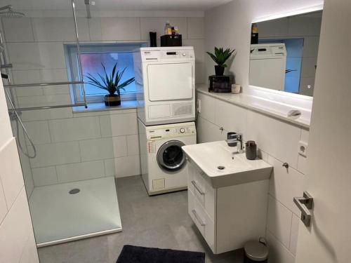 een badkamer met een wasmachine en een wastafel bij Ferienwohnung Hereinspaziert in Wilhelmshaven