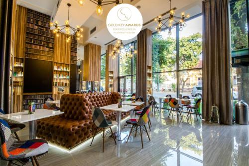 un restaurant avec des chaises et des tables dans une bibliothèque dans l'établissement Science Hotel, à Szeged