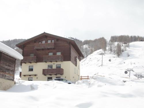 a building in the snow with a snow covered yard at Modern Holiday Home in Livigno Italy near Ski Area in Livigno