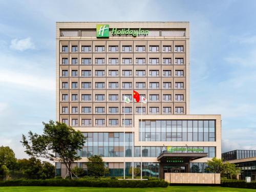 um edifício alto com um sinal em cima em Holiday Inn Xi'an East, an IHG Hotel em Xi'an