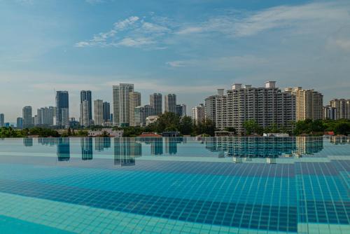 a large swimming pool with a city in the background at Deluxe Seaview Suite King Bed by The Only Bnb in Tanjong Tokong