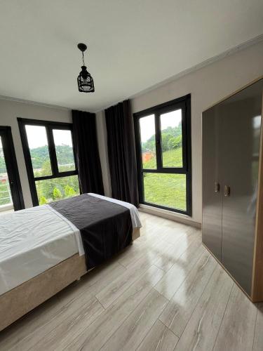 a bedroom with a bed and large windows at Noğa Suit Apart in Pazar