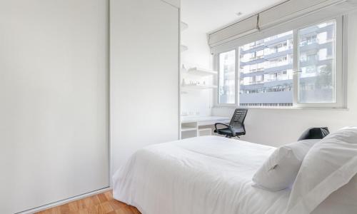 um quarto branco com uma cama branca e uma cadeira em Tabas Maravilhoso apê 3 quartos Leblon LB0035 no Rio de Janeiro