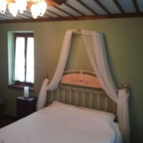 a bedroom with a bed with curtains over it at Yono's Traditional House in Ano Ravenia