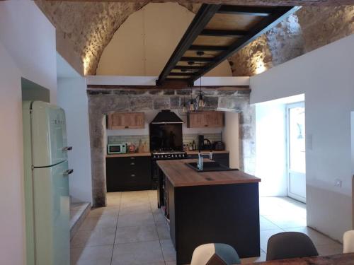 une cuisine avec une cuisinière et un réfrigérateur dans l'établissement Gite de La Louverie, à Mostuéjouls