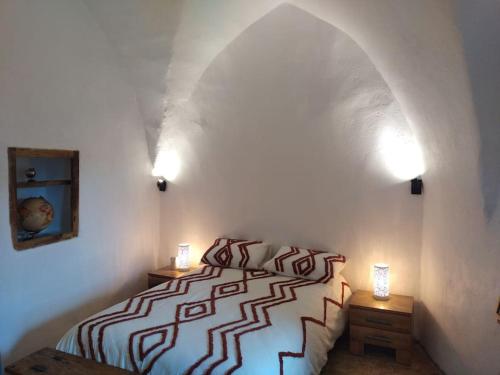 une chambre avec un lit et deux tables de nuit avec lampes dans l'établissement Gite de La Louverie, à Mostuéjouls