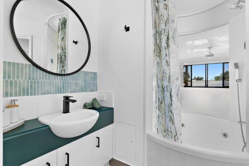 a bathroom with a sink and a mirror at Sun Drenched Unit in Noosaville in Noosaville
