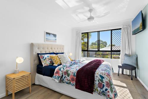 a bedroom with a bed and a window at Sun Drenched Unit in Noosaville in Noosaville