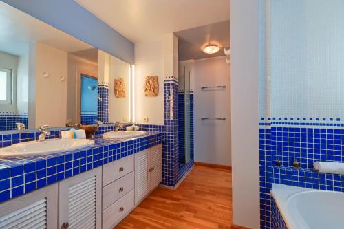 ein blau gefliestes Bad mit 2 Waschbecken und einer Dusche in der Unterkunft Ca Martin in Pedreguer