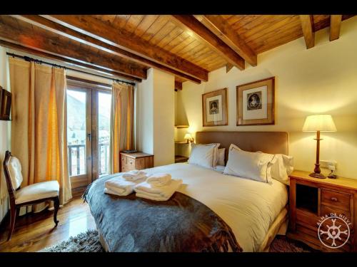 een slaapkamer met een groot bed en 2 handdoeken bij MULLERES de Alma de Nieve in Arties