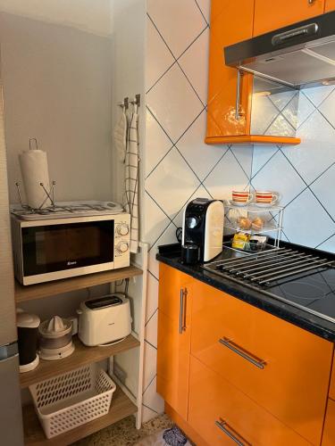 Una pequeña cocina con microondas y estufa. en Estudio en Plaza del Charco, en Puerto de la Cruz