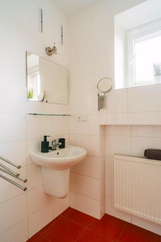 a white bathroom with a sink and a mirror at Apartmány Špička - Stříbrnice u sjezdovky in Staré Město