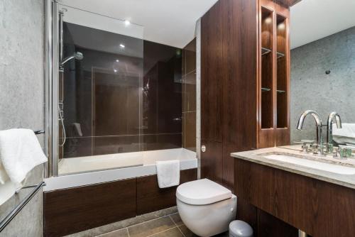 a bathroom with a toilet and a tub and a sink at Luxury modern 2BD flat in centre in London