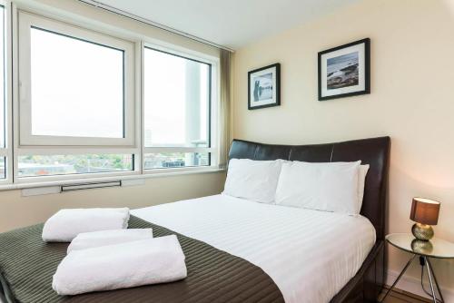 um quarto com uma cama grande e 2 janelas em Luxury modern 2BD flat in centre em Londres