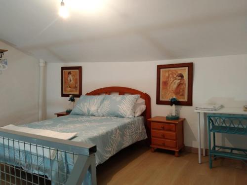 a bedroom with a bed and a table with a night stand at A Casiña in Mazaricos