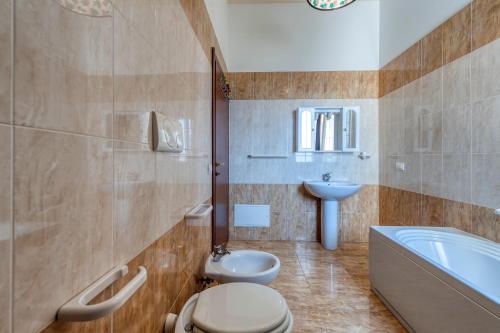 een badkamer met een toilet, een wastafel en een bad bij Solebarocco del sud - trilocale in Vernole