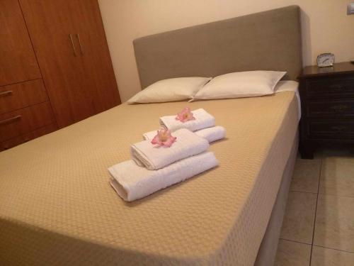 a bed with two towels and two towels at VILLA AVATOS - Near to the port of Rafina and the airport of Athens in Áyios Spirídhon