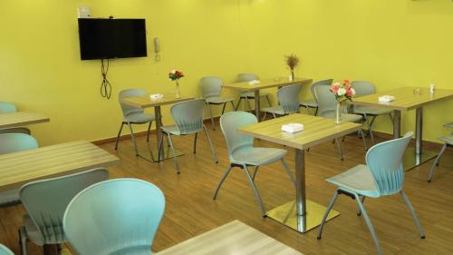 a room with tables and chairs and a flat screen tv at Morninginn, Yanling Jinggang Road in Ling