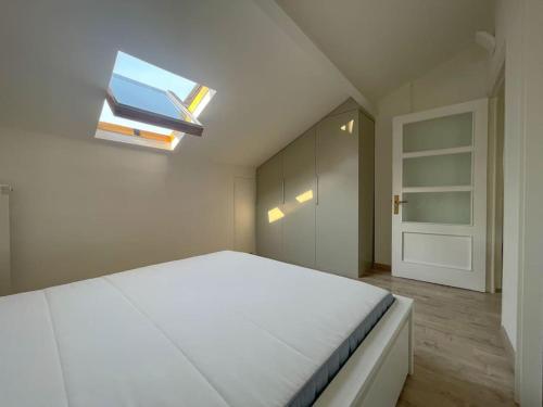 a bedroom with a large bed with a skylight at Mansarda vista mare in Imperia