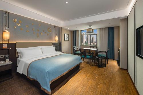 長沙市にあるTill Bright Hotel, Changsha Yanghu University of Traditional Chinese Medicineのベッドとダイニングルームが備わるホテルルームです。