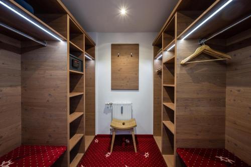 ein Zimmer mit Holzwänden und einem Stuhl in der Mitte in der Unterkunft Sporthotel Walliser in Hirschegg