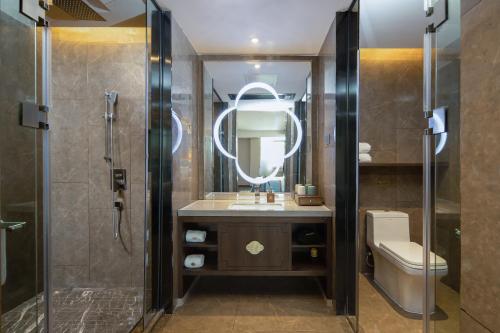 ein Badezimmer mit einem Waschbecken, einem WC und einem Spiegel in der Unterkunft Till Bright Hotel, Changsha Yanghu University of Traditional Chinese Medicine in Changsha
