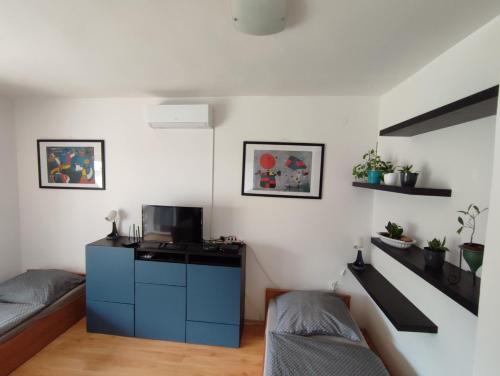 バラトンレッレにあるAranyharmat Apartmanの小さなリビングルーム(ベッド2台、ソファ付)