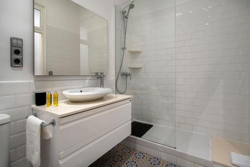 y baño blanco con lavabo y ducha. en Habitat Apartments Eixample Balconies., en Barcelona