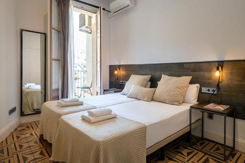 バルセロナにあるHabitat Apartments Eixample Balconies.のベッドルーム1室(白い大型ベッド1台、テーブル2台付)