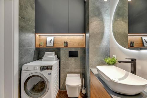 a bathroom with a washing machine and a sink at Downtown Apartments Bastion Wałowa City Center & Parking in Gdańsk