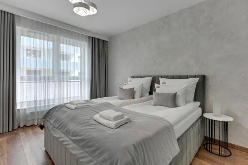 sypialnia z 2 łóżkami i dużym oknem w obiekcie Downtown Apartments Bastion Wałowa City Center & Parking w Gdańsku