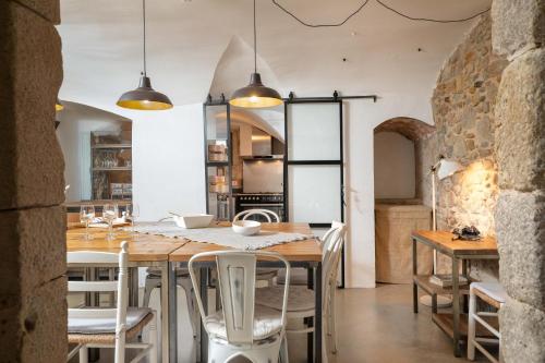 een keuken en eetkamer met een houten tafel en stoelen bij Flateli Corçà Townhouse in Corçà