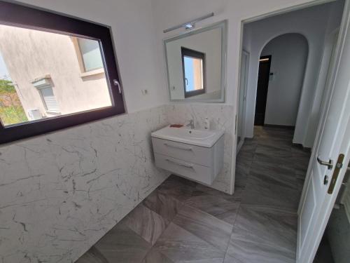 a bathroom with a sink and a mirror at Leon Apartment in Constanţa