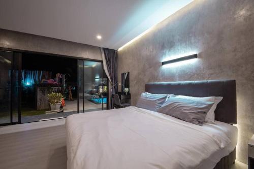 a bedroom with a large bed and a large window at Ma PoolVilla Khanom in Khanom