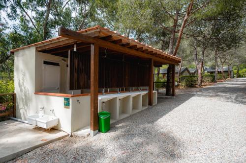a small white building with a wooden roof at Glamping at Elba in Lacona
