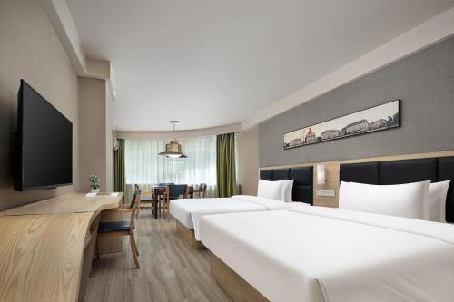 a hotel room with two beds and a flat screen tv at Morninginn, Tidu Middle Road in Lengshuijiang
