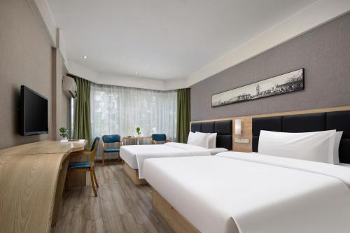 a hotel room with two beds and a desk at Morninginn, Tidu Middle Road in Lengshuijiang