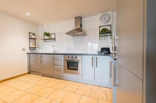 a kitchen with stainless steel appliances and a tile floor at Sidemersey Livings- Rare Accessible 2BR Liverpool City Centre Apartment in Liverpool
