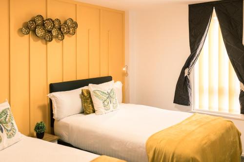 a bedroom with two beds and a window at Central Oasis, Serene Convenient 2-Bedroom Haven in L1 in Liverpool