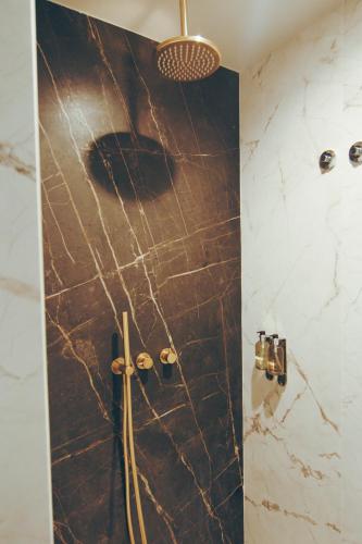 a bathroom with a shower with black marble at Estalagem Santa Iria Hotel & Spa in Tomar