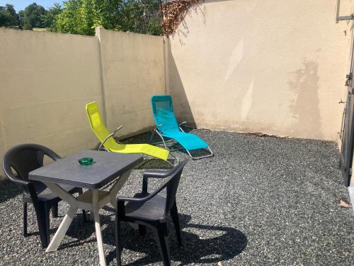 um grupo de cadeiras e uma mesa num quintal em Studio le cosy centre de gaillon(wifi) em Gaillon