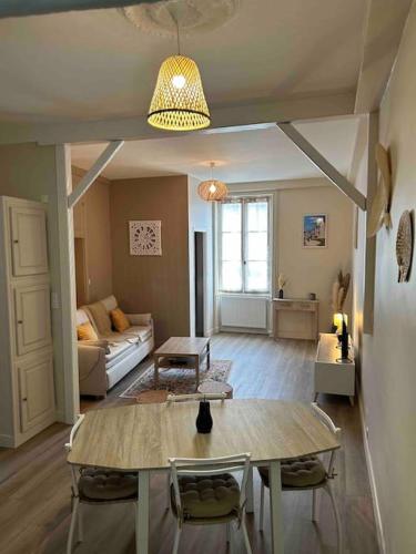 sala de estar con mesa y sofá en Downtown cozy cottage - 4 pl -, en Château-Gontier